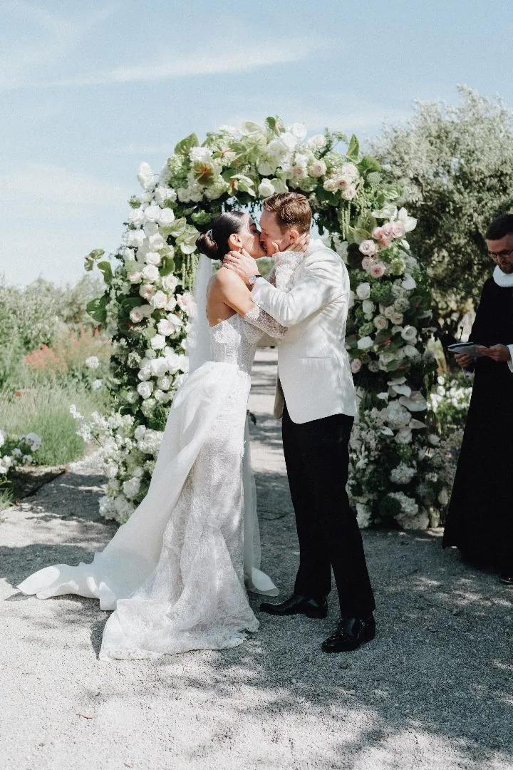 couple de mariés moderne sous une arche florale lors de leur cérémonie de mariage en Provence